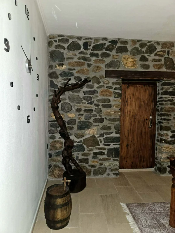 Ο διάδρομος με την ξύλινη πόρτα και τον πέτρινο τοίχο